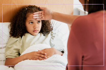 A poorly child in bed and her parent checking her temperature