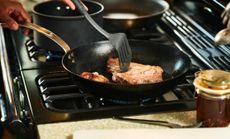 Steak being cooked in a pan on the hob