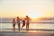 Family walking on beach at sunset