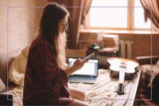 Young teenage girl sat in room with phone