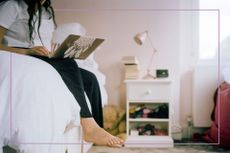 crop of teenage girl sitting on bed and using laptop computer