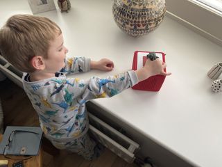 Four year old placing a Tonie character on top of the Toniebox