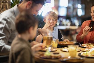 Family with kids eating together in a restaurant