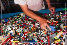 Close up of hands sorting through a tray of LEGO bricks