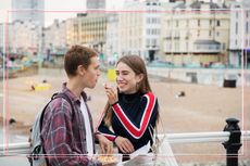 A teenage boy and girl smiling together on a pier